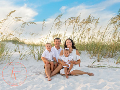 family sitting on beach in destin for photography