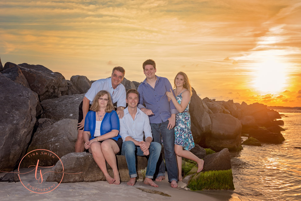 family posing on beach in destin at sunset