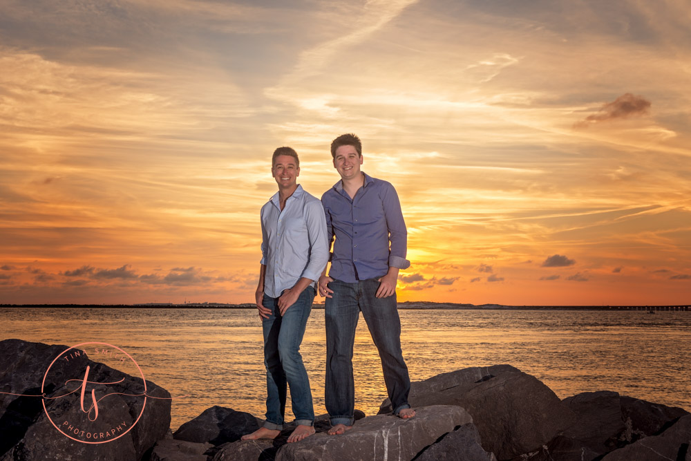 brothers posing on jetty in destin at sunset