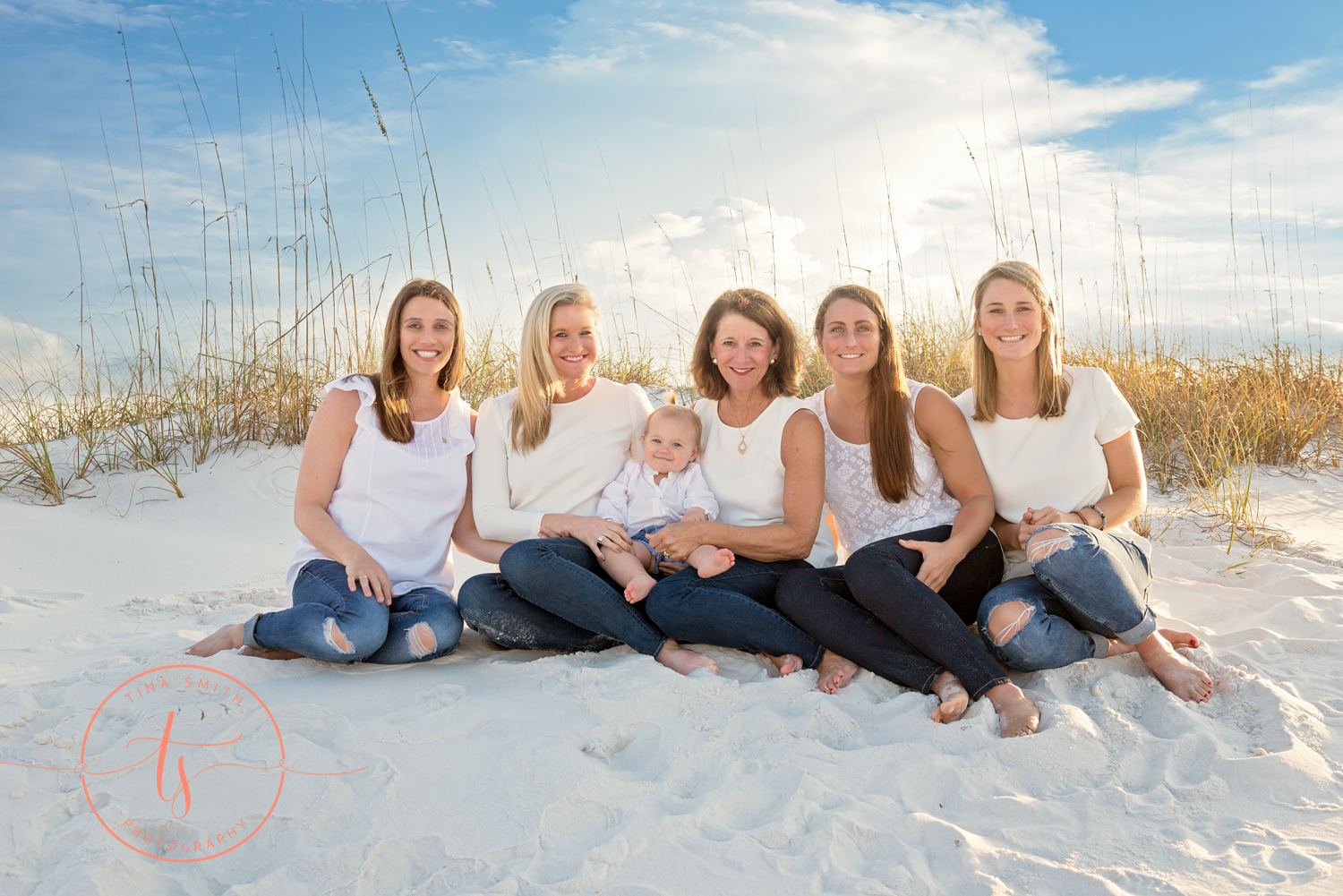 all girls sitting on beach smiling for photographer