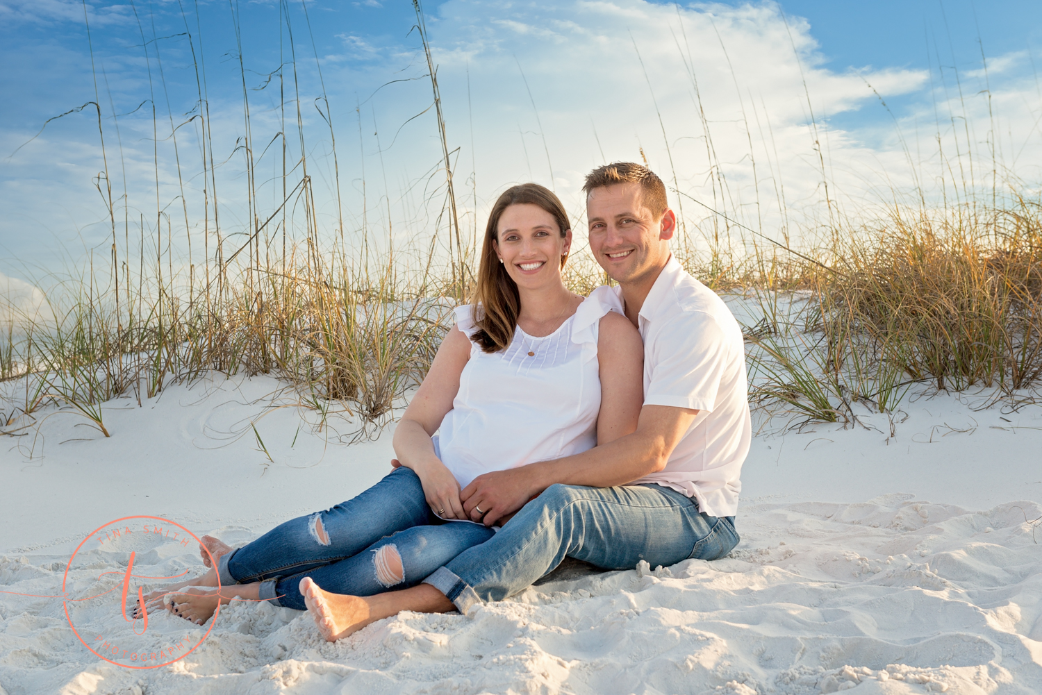 couple sitting in sand on beach in destin