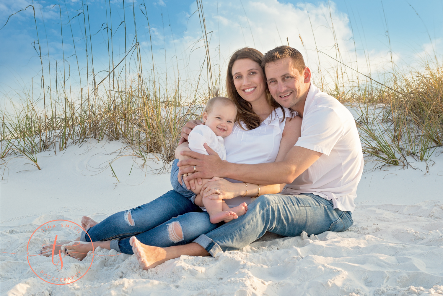 mom dad baby hugging on beach in destin