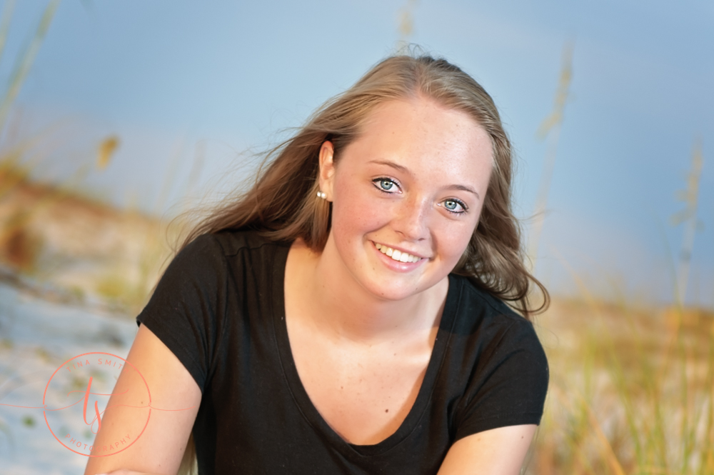 senior girl in black shirt posing on beach in destin