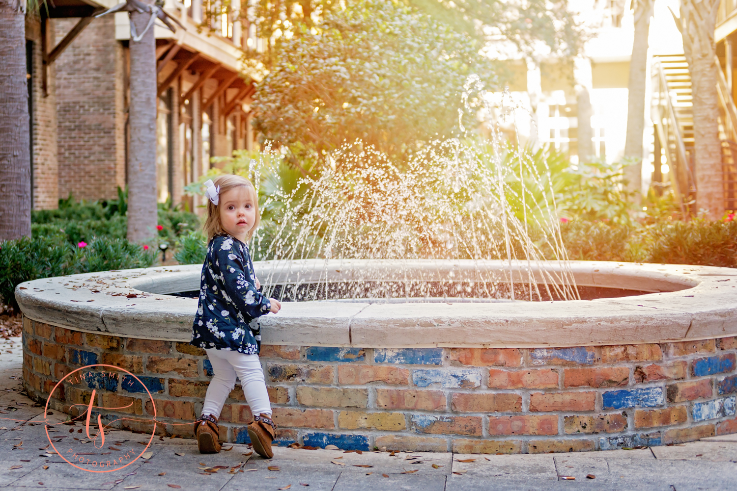 girl standing in front of fountain baytowne wharf 