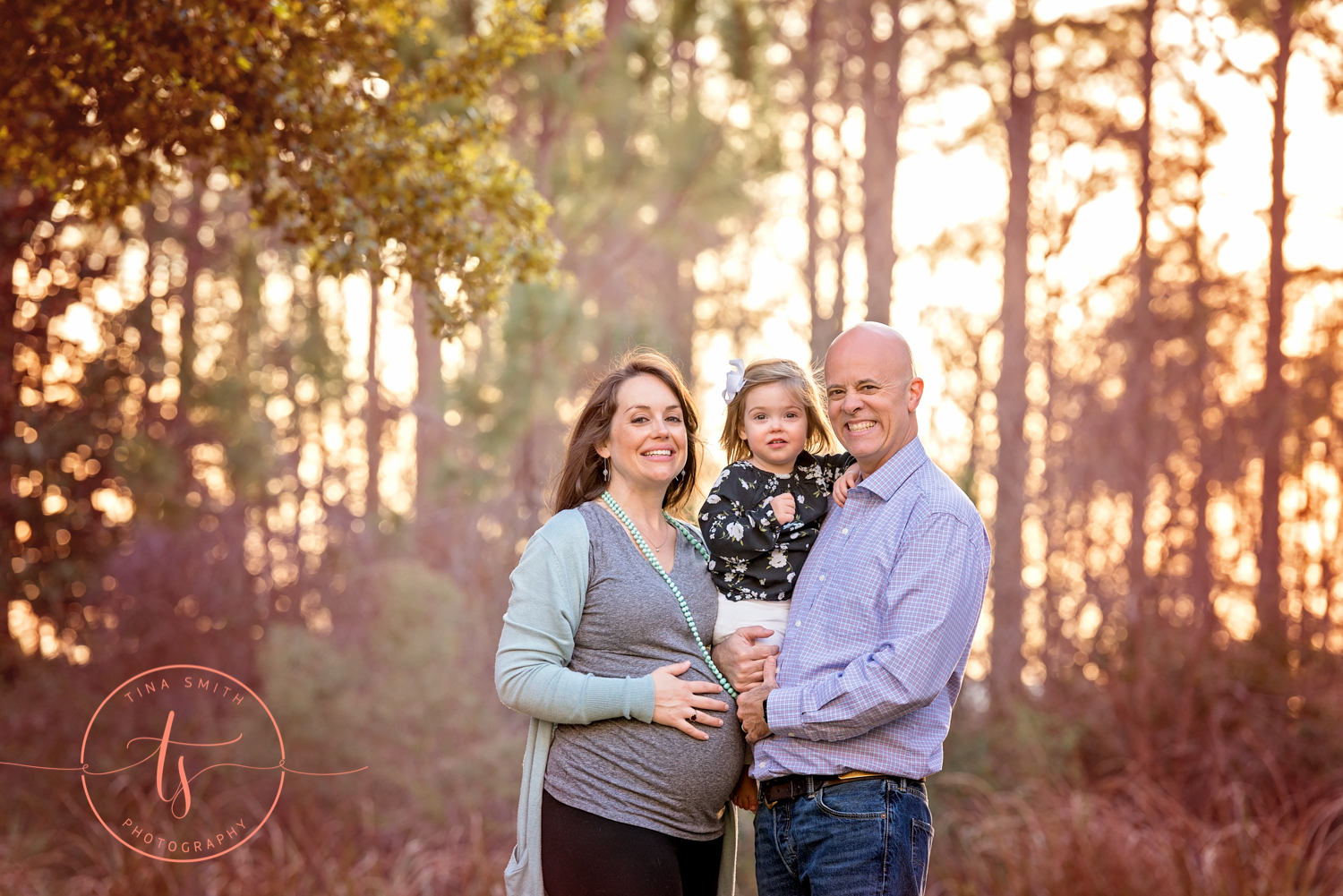 mom dad holding baby and smiling