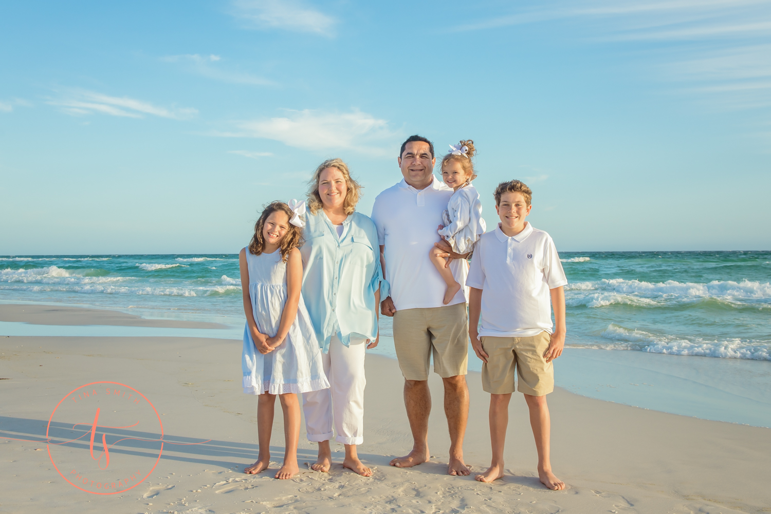 family posing on watersound beach smiling for photographer