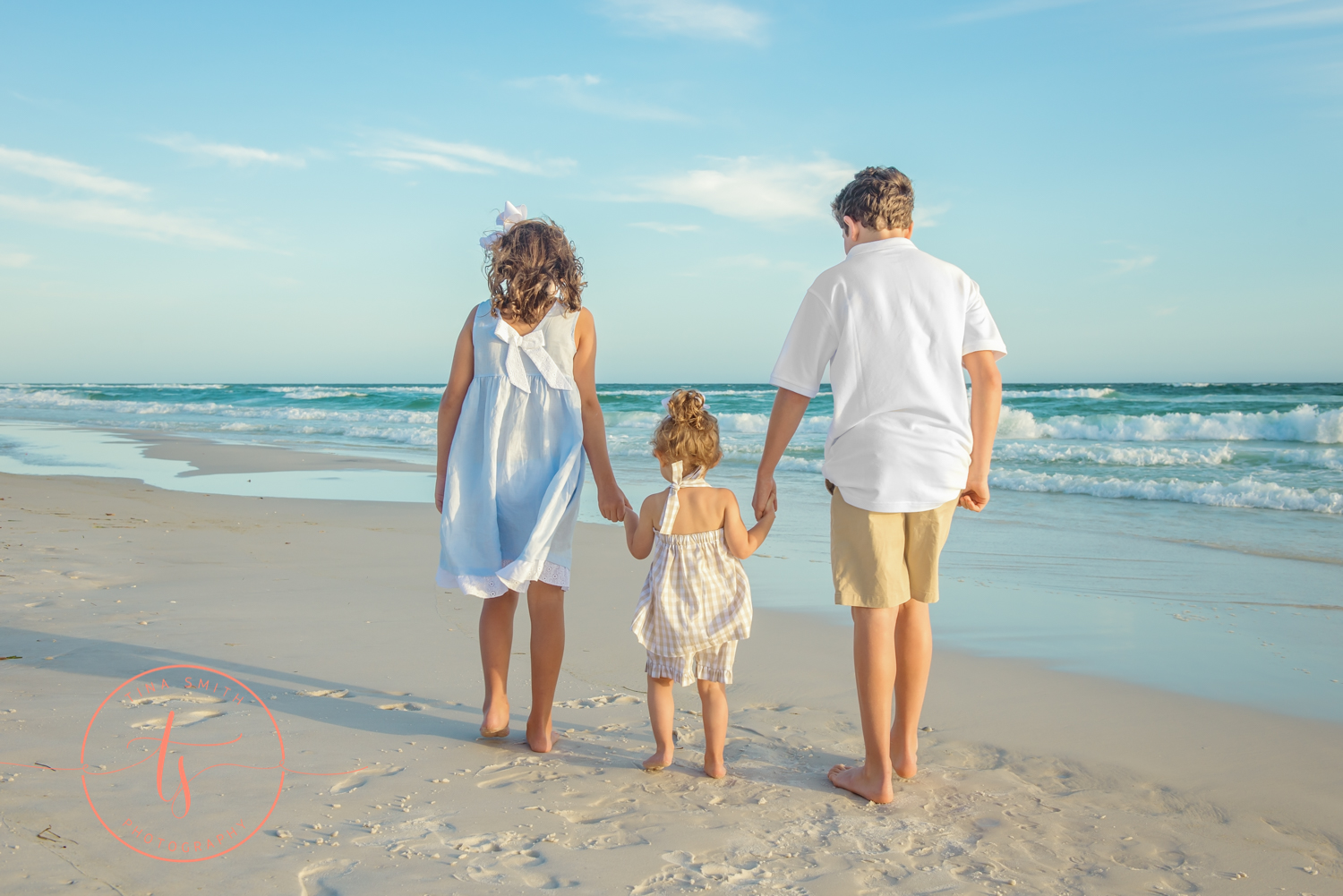 children walking down watersound beach holding hands