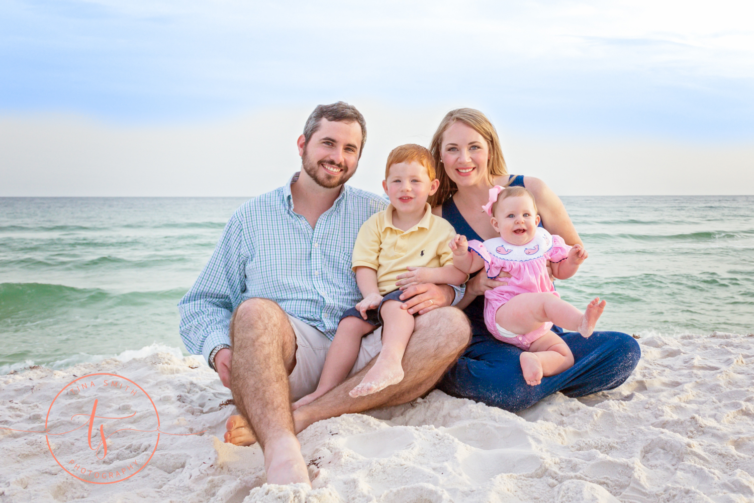 family sitting on beach in destin for portraits