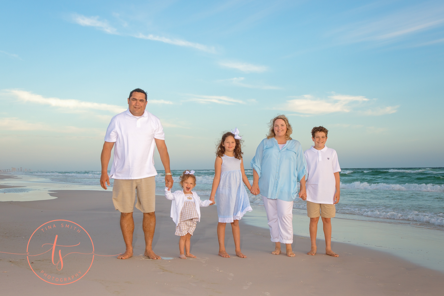 family walking in the waters edge on watersound beach holding hands