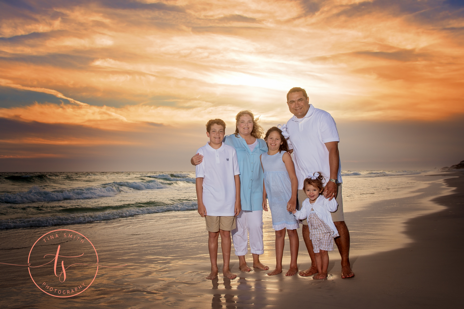 family on watersound beach posing at sunset for photographer