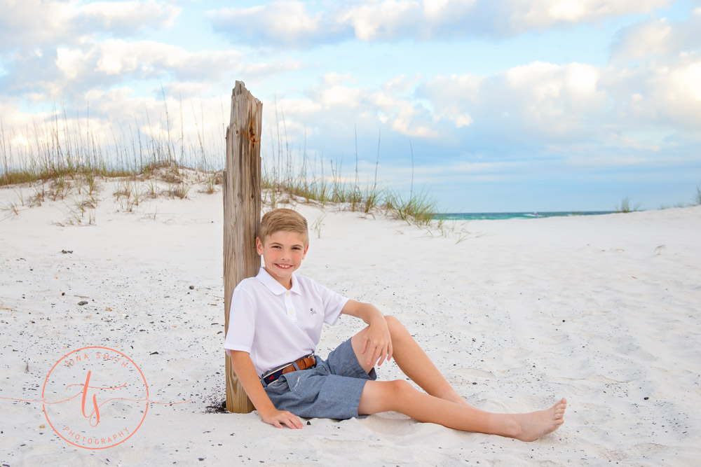 boy leaning against beach pole in destin