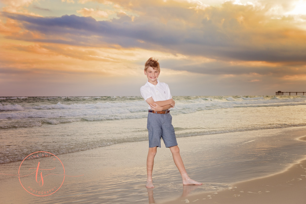 boy standing on beach at sunset