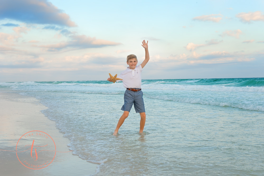 boy splashing in water on beach