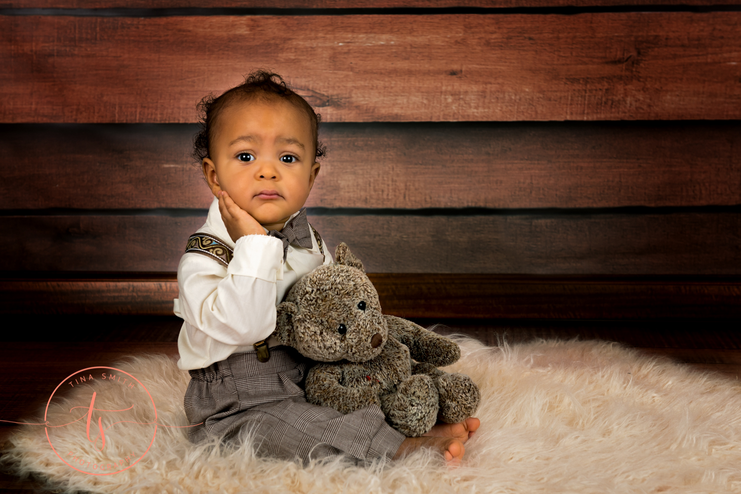 boy in page boy outfit holder a bear for studio portraits