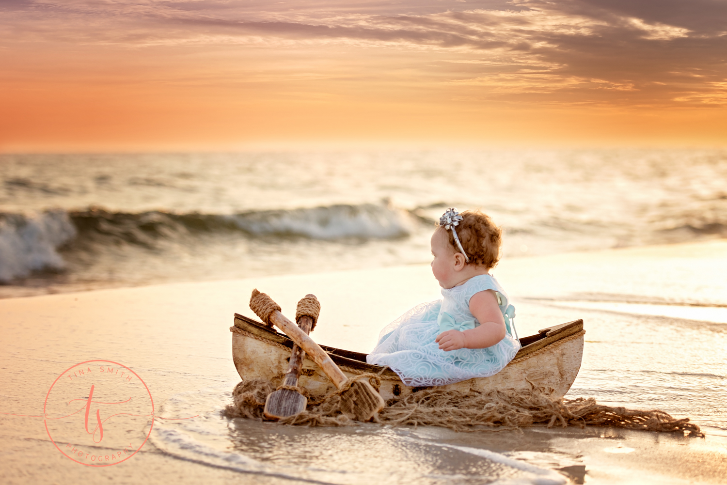 baby girl sitting in a canoe in the water at the beach in destin