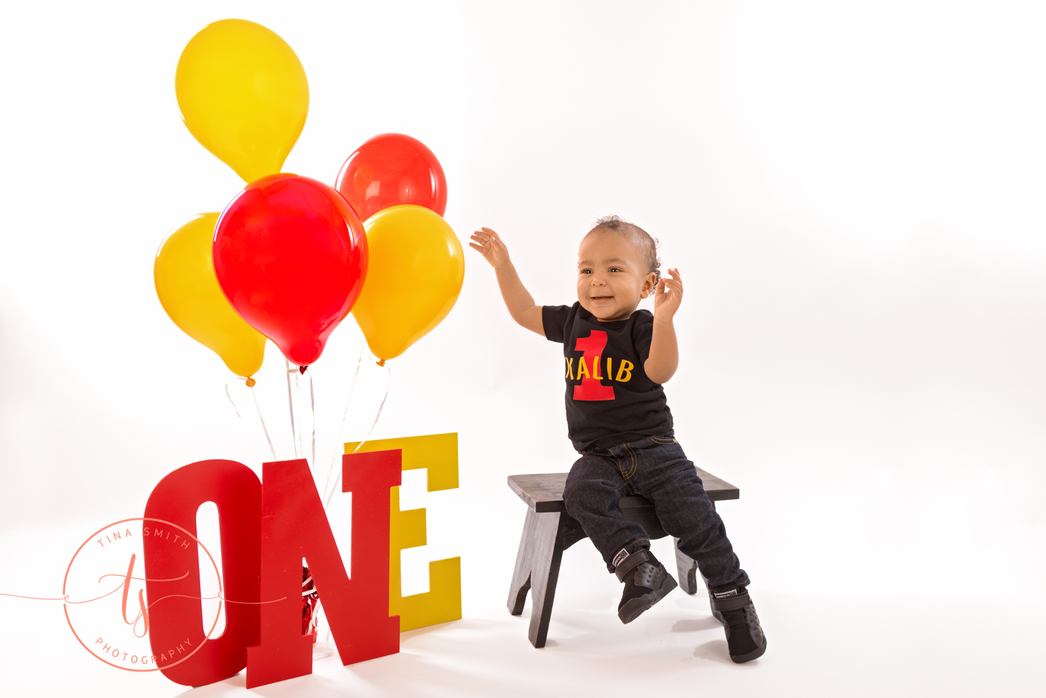 boy in 1 year shirt with mickey mouse and balloons