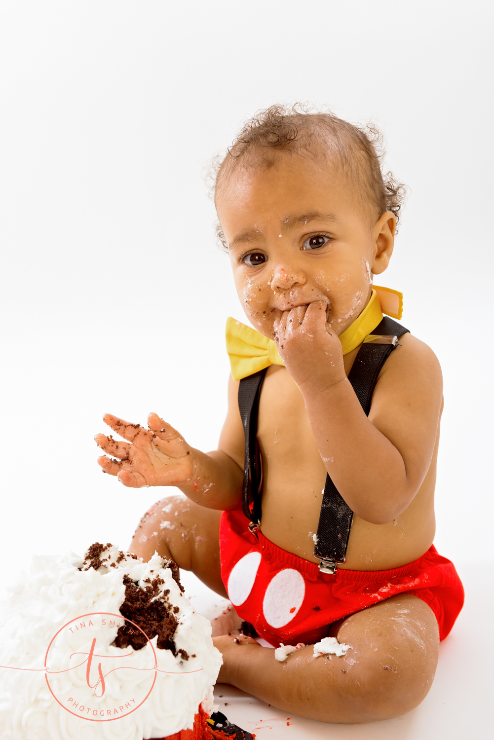 boy in mickey mouse outfit eating cake in destin studio