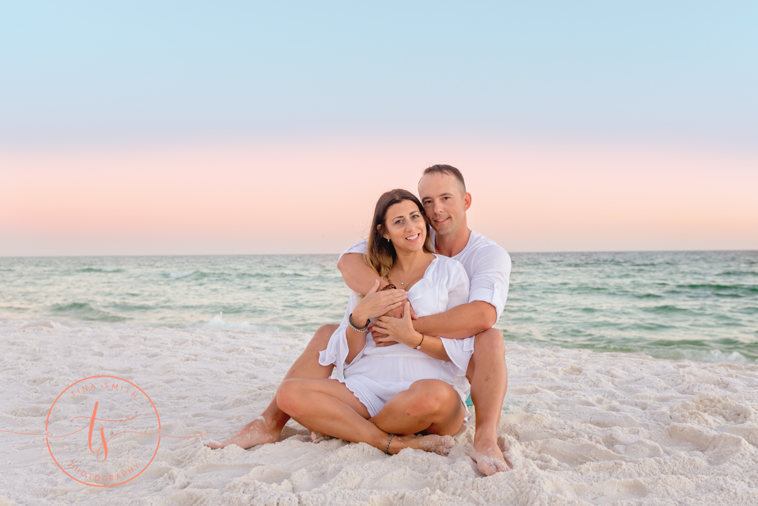 couple siting on beach at sunset in destin