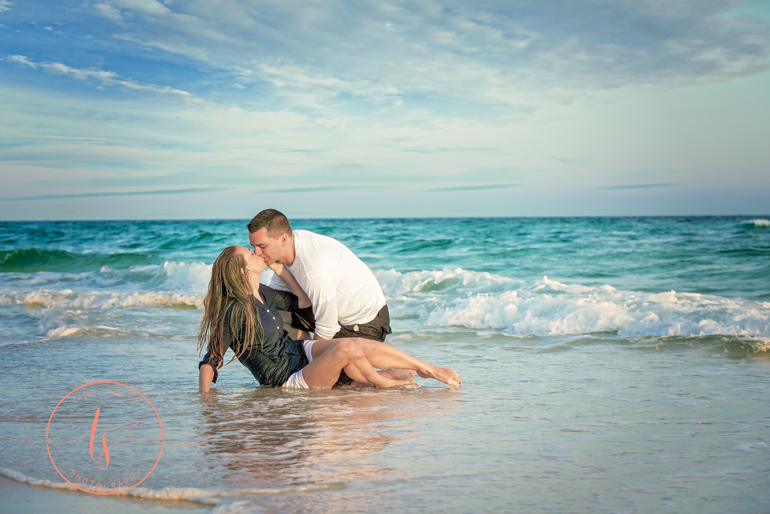 engaged couple posing in water in destin
