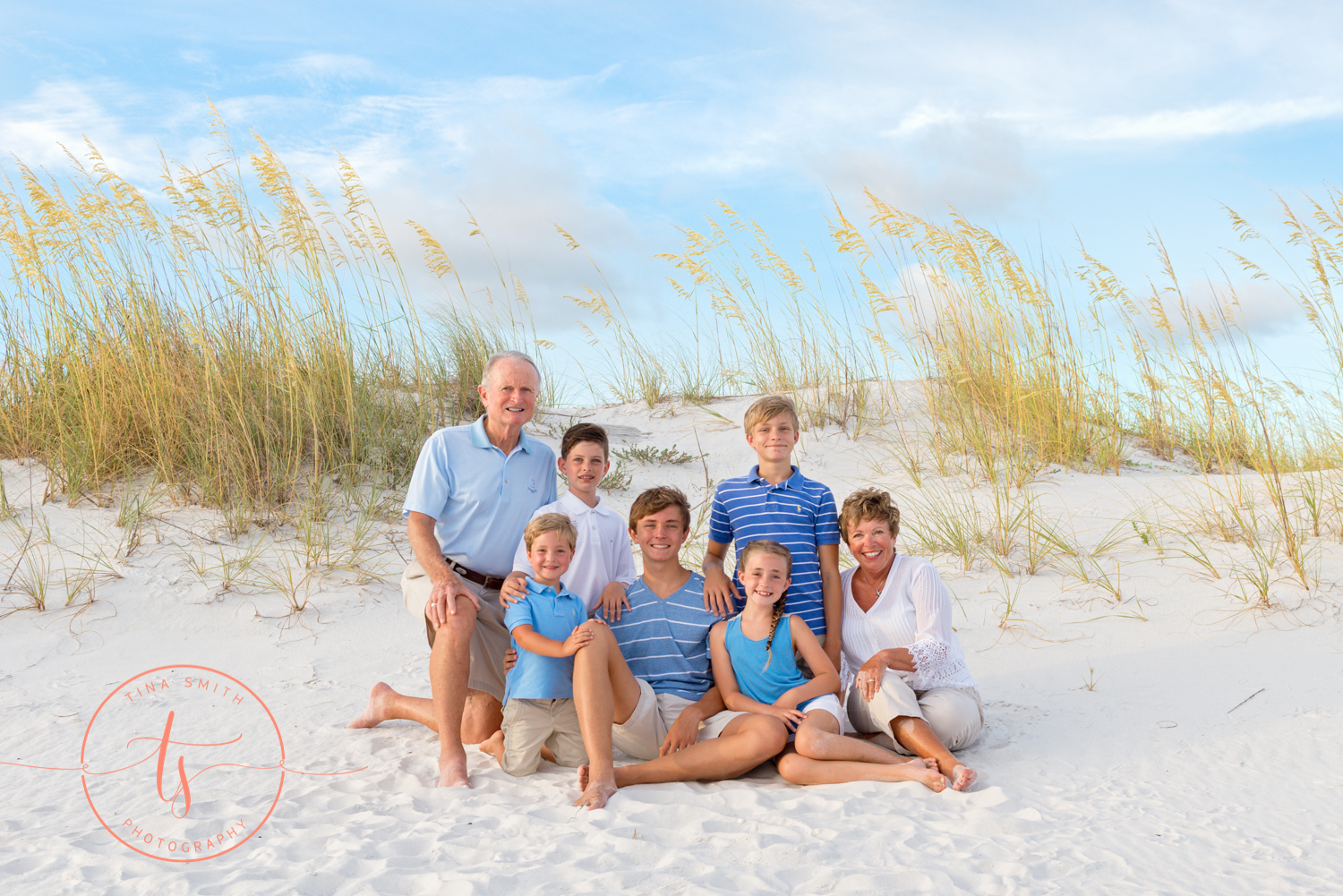 destin family sitting on the beach posing for photographer