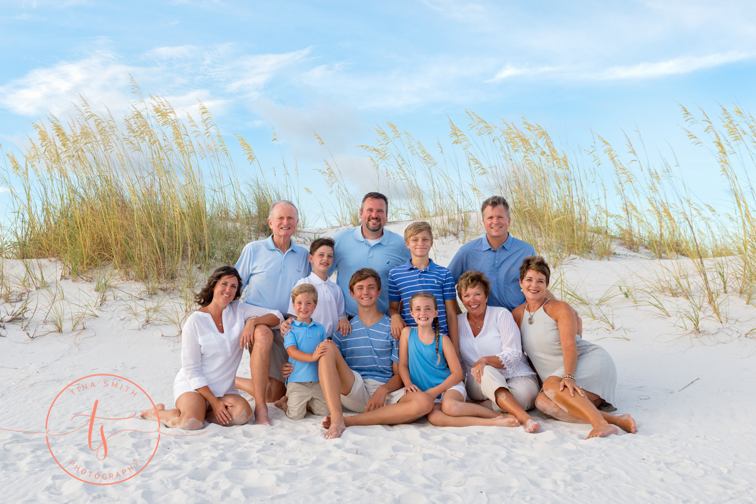 large family sitting on the beach in destin posing for photos