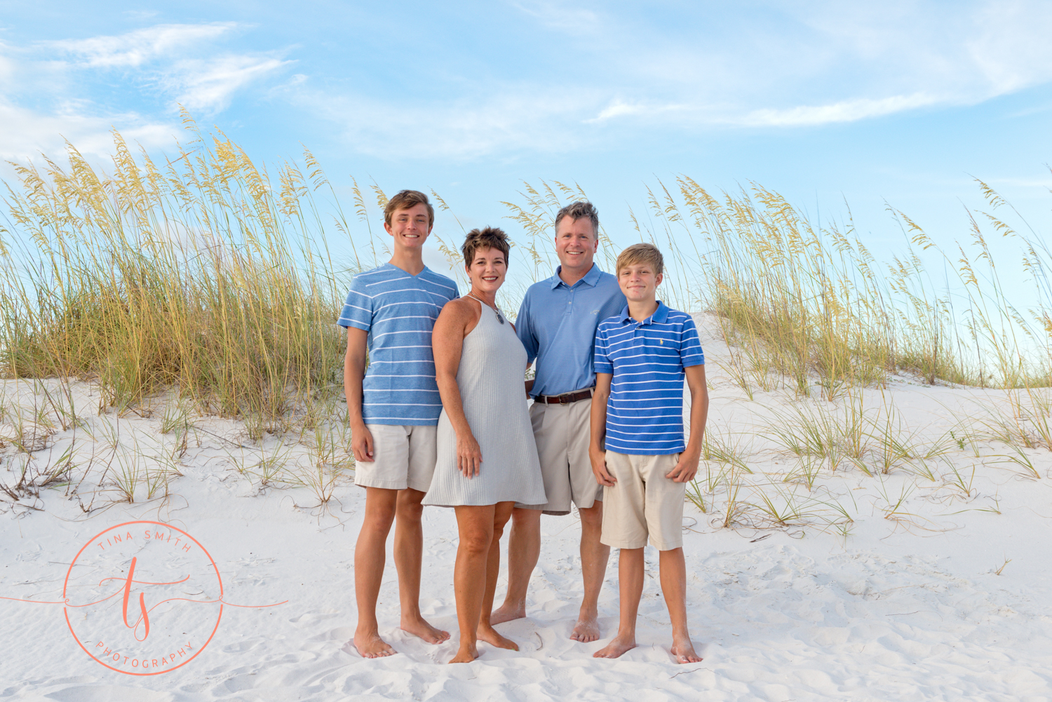 family of 4 posing for destin photographer on the beach dressed in blue