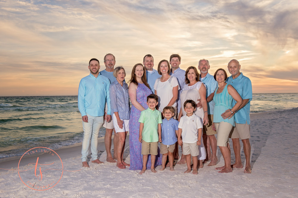 family posing on beach in miramar at sunset