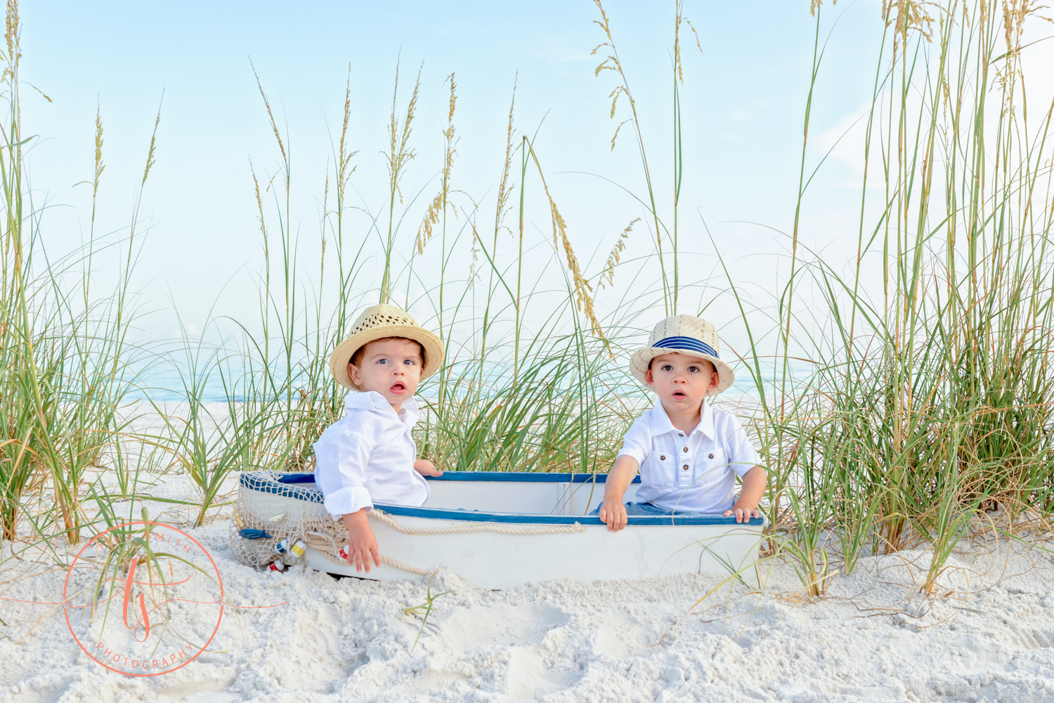 2 boys in a boat on the beach posing for destin photographer