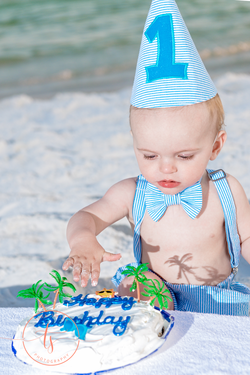 boy eating 1st birthday cake on beach in destin