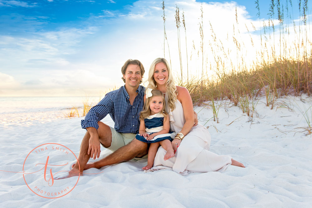 family of 3 sitting on the beach for destin family beach photographer