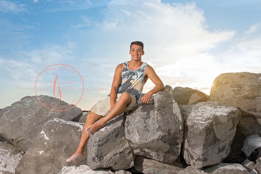 destin senior portraits photographer boy sitting on the jetties