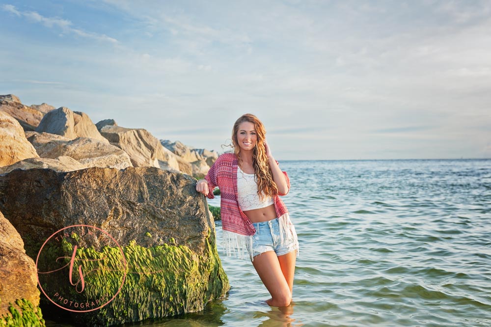 girl posing for destin senior photographer in the water