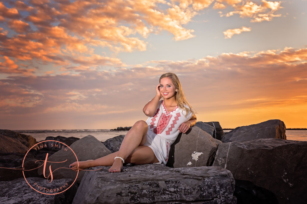 senior girl in white romper posing n beach n destin