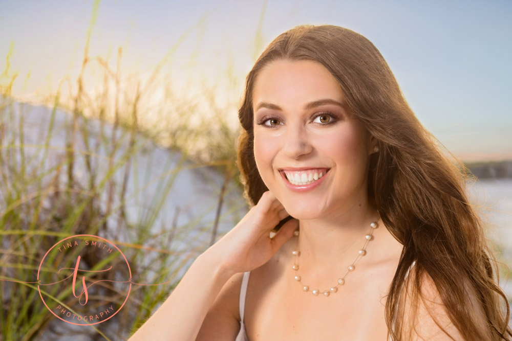 destin senior photographer girl posing in front of sea oats and sand dunes
