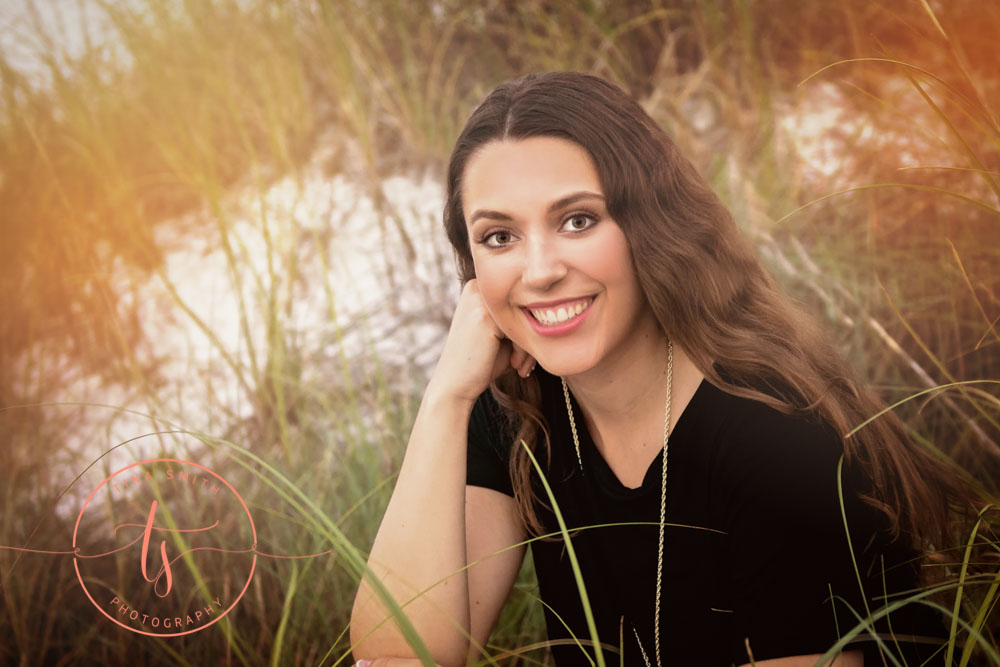 senior girl posing in sea oats on beach in destin