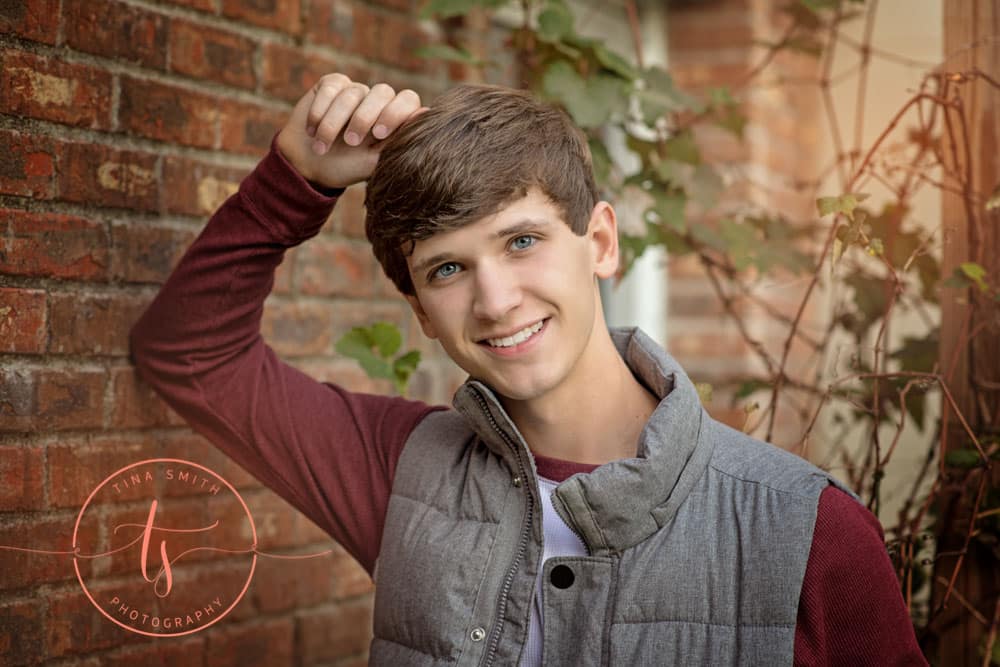 senior guy posing on brick wall ft walton beach high school