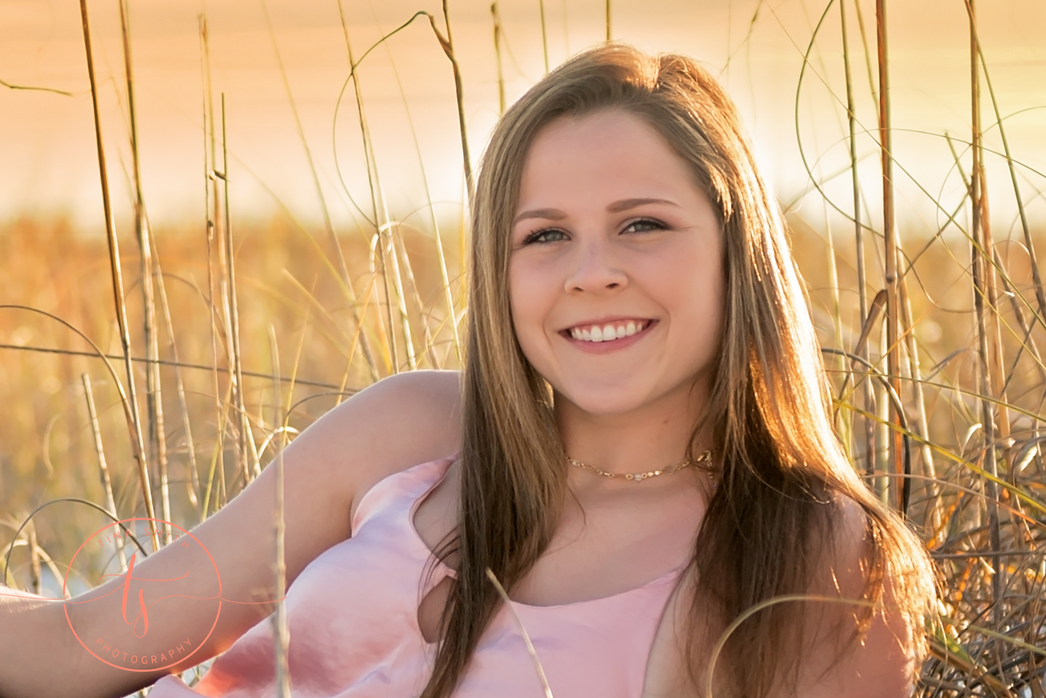 senior girl on the beach in destin with se oats and sunset 