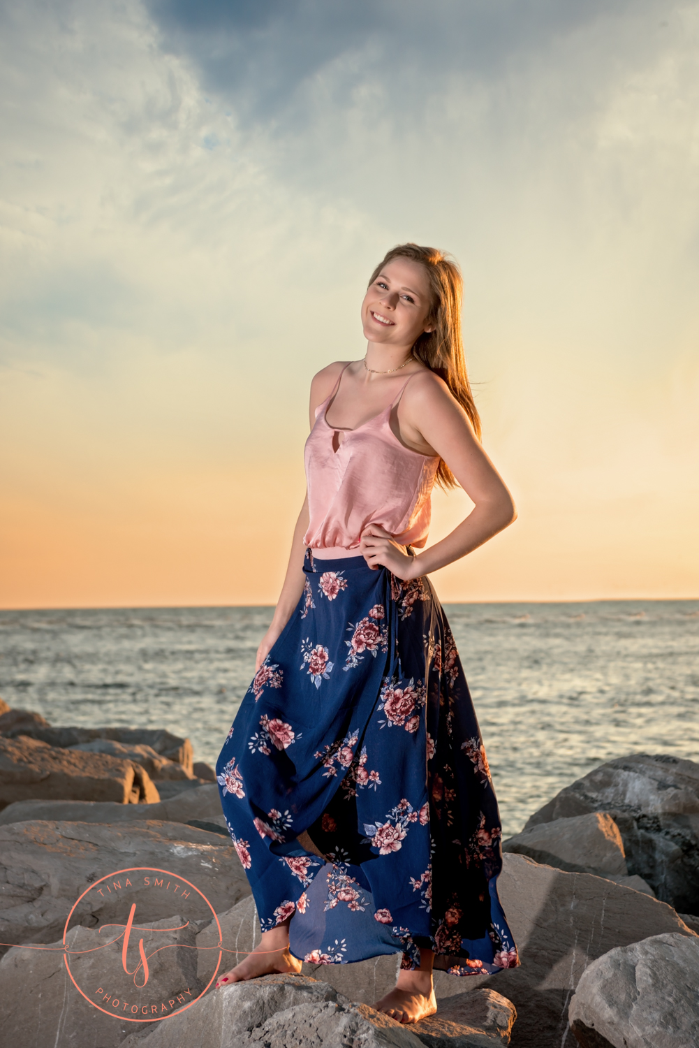 senior girl in skirt posing infant of sunset in destin