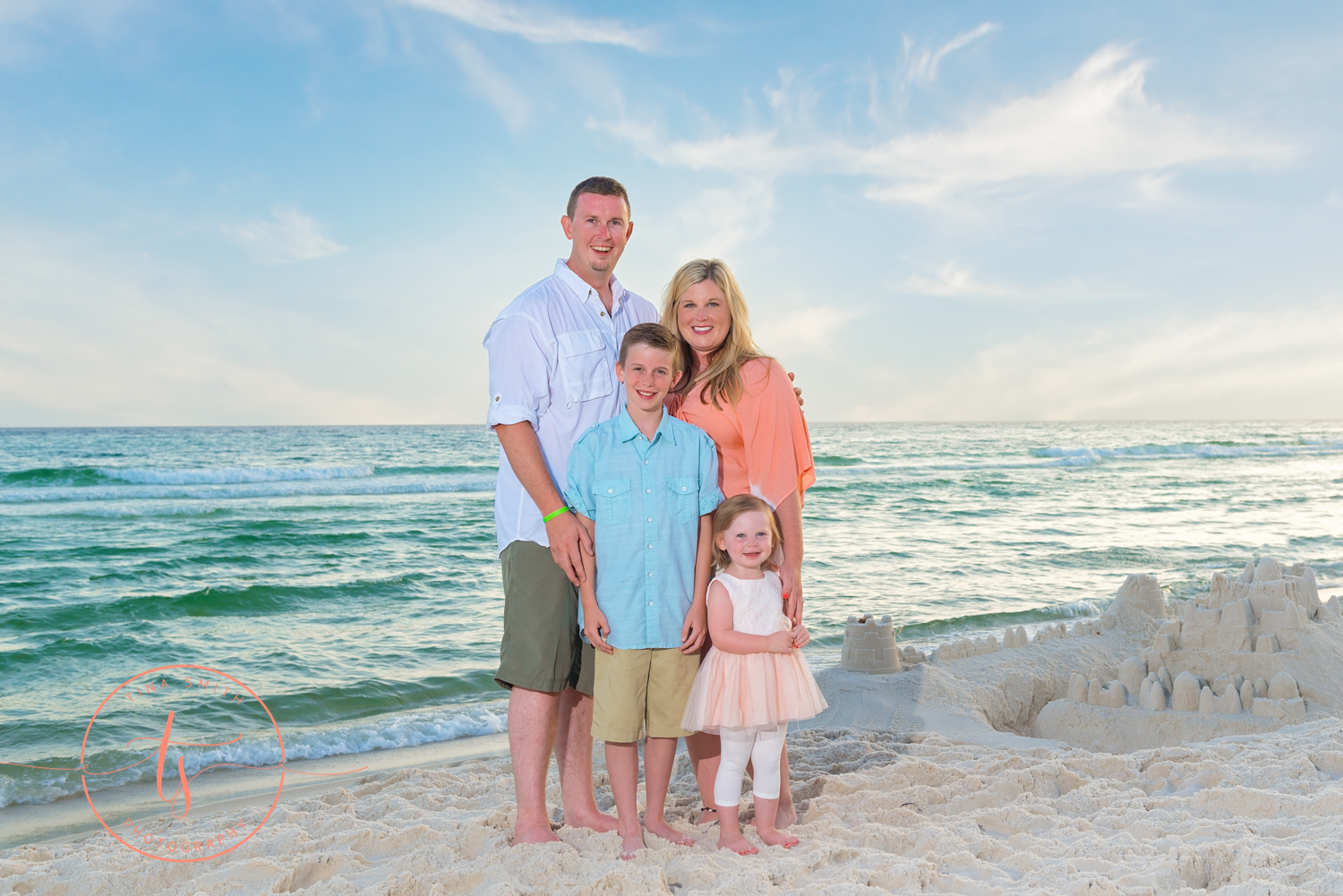 family of 4 posing on the seacrest beach 